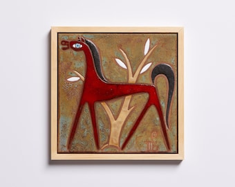 May include: A framed ceramic tile with a stylized red horse standing in front of a brown tree with white leaves. The horse has a black mane and tail and a blue eye. The tile has a brown background with a green and blue glaze.