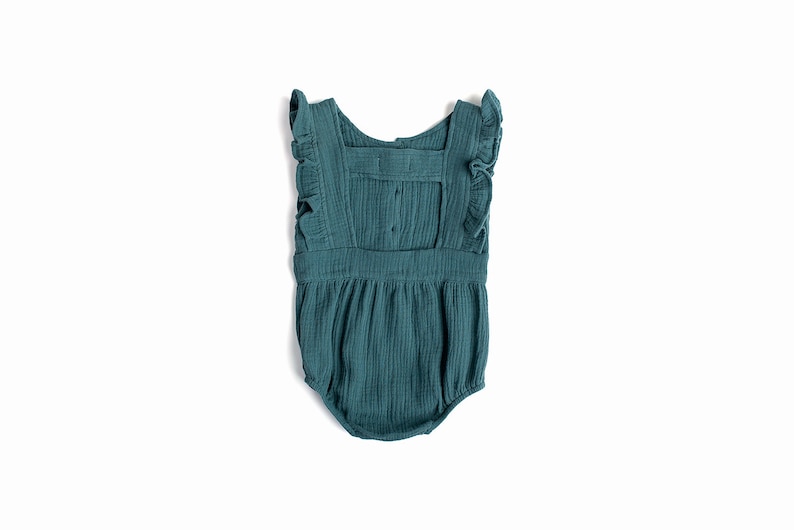 May include: A teal blue baby onesie with ruffled straps and a gathered skirt. The onesie has a button closure at the back.