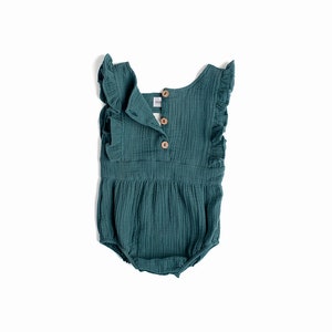 May include: A teal blue baby onesie with ruffled sleeves and a button closure in the back. The onesie is made of a soft, textured fabric.