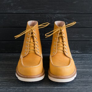 Puede incluir: Un par de botas de cuero marr&oacute;n con cordones y suela blanca. Las botas tienen un dise&ntilde;o cl&aacute;sico y est&aacute;n hechas de cuero de alta calidad.