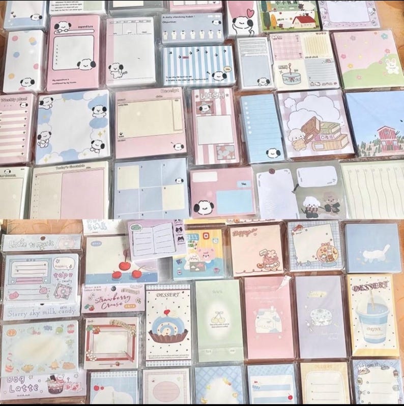 May include: A collection of various stationery items, including notepads and sticky notes, in a variety of pastel colors. Many feature cute cartoon dog illustrations. Some items have text, such as "Strawberry Cruise" and "Dessert".