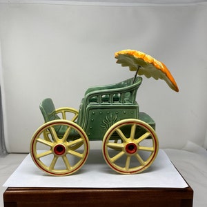 Vintage McCoy Buggy Wagon Keramik Pflanzer mit rollenden Wagenrädern und einem Regenschirm.