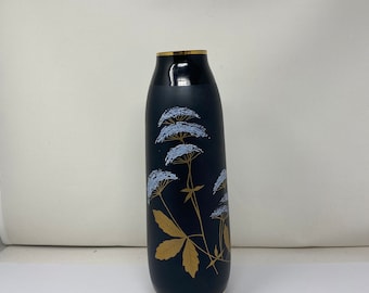 Vase en verre noir et blanc doré avec des papillons.