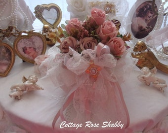 Vase in its armful of roses, shabby boudoir, and its lace adornment, imbued with softness!