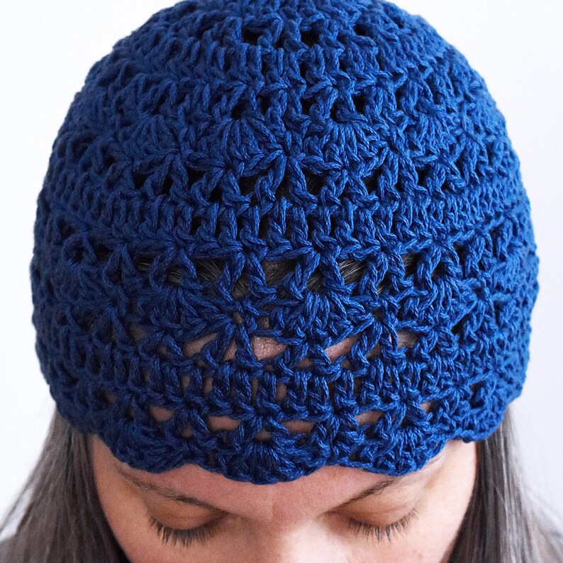 Puede incluir: Un gorro de ganchillo azul profundo que presenta un patr&oacute;n repetitivo en forma de estrella en toda la tela. El gorro est&aacute; construido con hilo texturizado y tiene un borde festoneado a lo largo del dobladillo inferior, creando un acabado decorativo.
