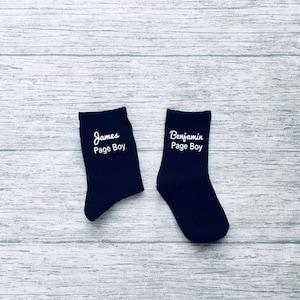 May include: Two pairs of black socks with white text. One sock says "James Page Boy" and the other says "Benjamin Page Boy".