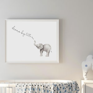 May include: A white framed print with a watercolor illustration of a grey elephant with the text "dream big little one" written in cursive.