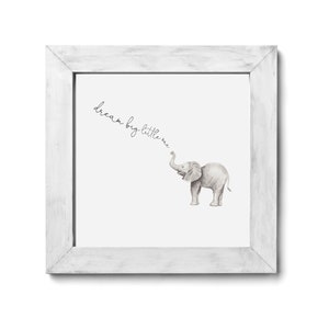 May include: A white framed print with a watercolor illustration of a gray elephant with the text "dream big little one" written in cursive.
