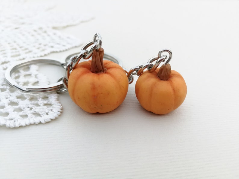 Puede incluir: Dos llaveros de calabaza naranja con anillas de plata. Las calabazas est&aacute;n hechas de arcilla polim&eacute;rica y tienen un aspecto realista.