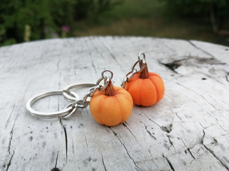 Puede incluir: Dos llaveros de calabaza naranja con anillas de plata. Las calabazas est&aacute;n hechas de arcilla polim&eacute;rica y tienen un aspecto realista.