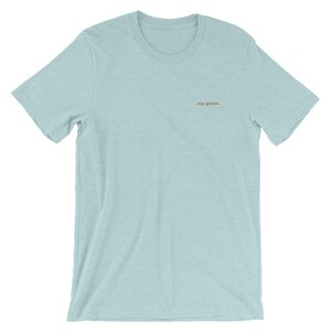Heather Prism Ice Blue short-sleeve tee with the phrase Stay Golden is embroidered in gold thread.