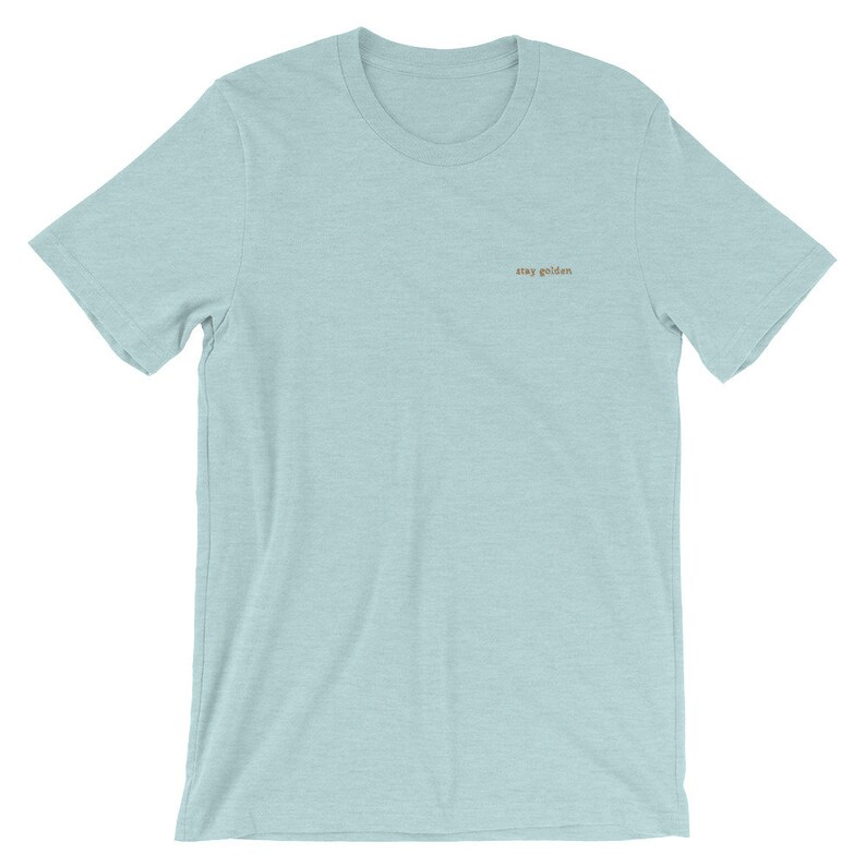 Heather Prism Ice Blue short-sleeve tee with the phrase Stay Golden is embroidered in gold thread.