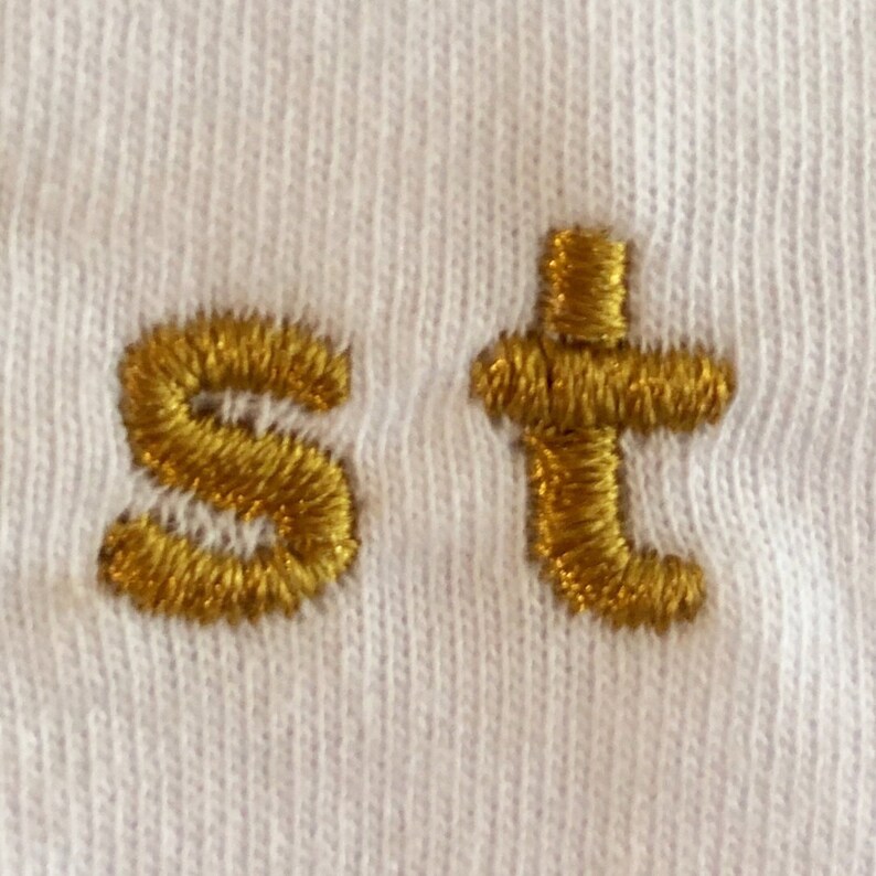 Close-up of embroidery on stay golden t-shirt.