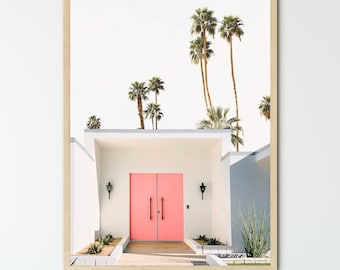 May include: A modern, white house with a bright pink double door entrance. Palm trees line the front of the house, creating a tropical vibe.