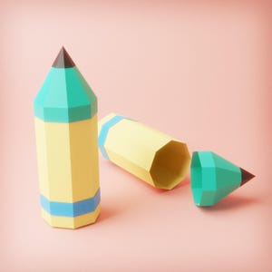 Może przedstawiać: Martwa natura z trzema geometrycznymi ołówkami w kolorze żółtym, turkusowym i niebieskim na różowym tle. Jeden ołówek stoi pionowo, drugi leży na boku, a trzeci jest oddzielony od korpusu. Ołówki mają czarne końcówki.