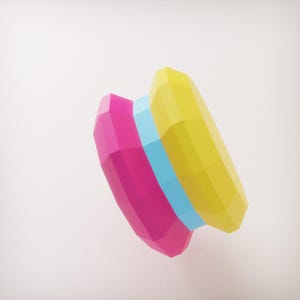 May include: A geometric sculpture featuring a combination of bright colors. The artwork has a pink, light blue, and yellow color scheme. The sculpture's design is angular and faceted, creating a modern and abstract aesthetic.