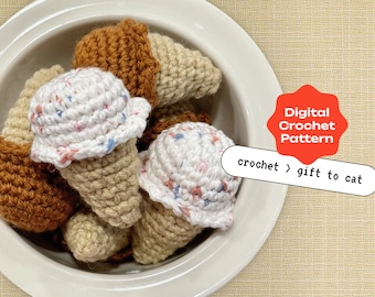 Può includere: Una ciotola di coni gelato all'uncinetto in marrone, bianco e blu. I coni sono fatti per assomigliare a giocattoli per gatti. Il testo "Digital Crochet Pattern" e "crochet > gift to cat" è sull'immagine.