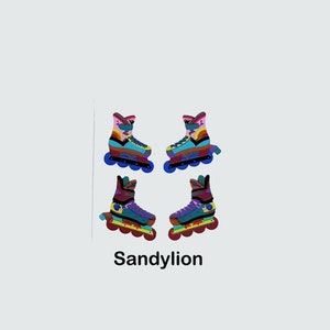 May include: Four colorful roller skate stickers with a rainbow design. The stickers are on a white background. The text "Sandylion" is below the stickers.
