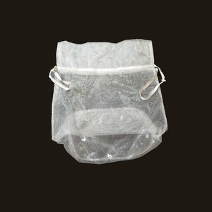 May include: A white sheer drawstring bag with a white zipper and white drawstrings.