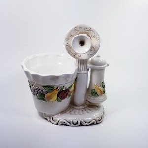May include: White ceramic planter shaped like an old-fashioned telephone with a floral design and fruit accents.