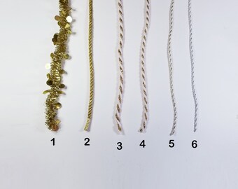 May include: Six different types of gold and white trim, labelled 1 through 6. The trim is for decorating crafts and gifts.