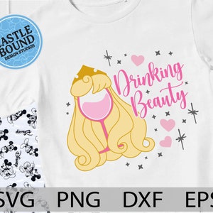 May include: A white t-shirt with a pink and gold design featuring a princess with a glass of wine and the text "Drinking Beauty".