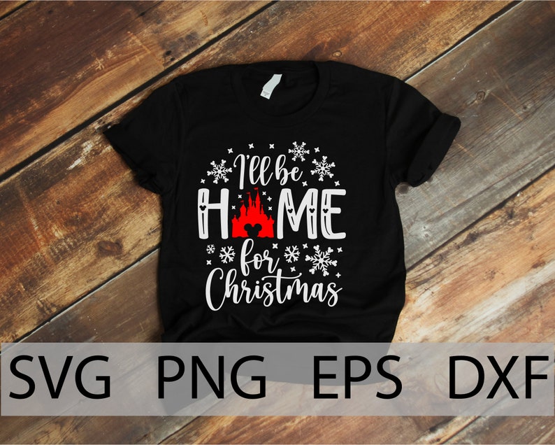 Może przedstawiać: Czarny T-shirt z białym nadrukiem, na kt&oacute;rym widnieje napis "I'll be home for Christmas" z sylwetką zamku Kopciuszka i uszami Myszki Miki w środku słowa "home".