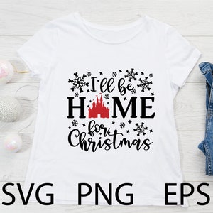 May include: White t-shirt with black text that reads "I'll be home for Christmas" with a red and black castle graphic in the middle. The text is surrounded by black snowflake graphics.