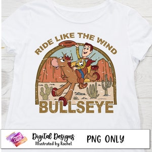 May include: A white t-shirt with a vintage-style graphic of Woody from Toy Story riding Bullseye. The graphic features a distressed background with the text "Ride Like The Wind Bullseye".