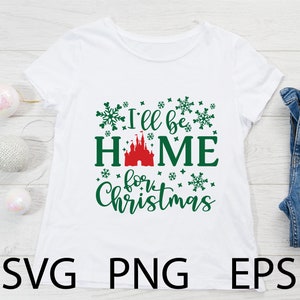 May include: White t-shirt with green text that reads "I'll be home for Christmas". The text is surrounded by green snowflakes. A red castle is in the middle of the word "home".
