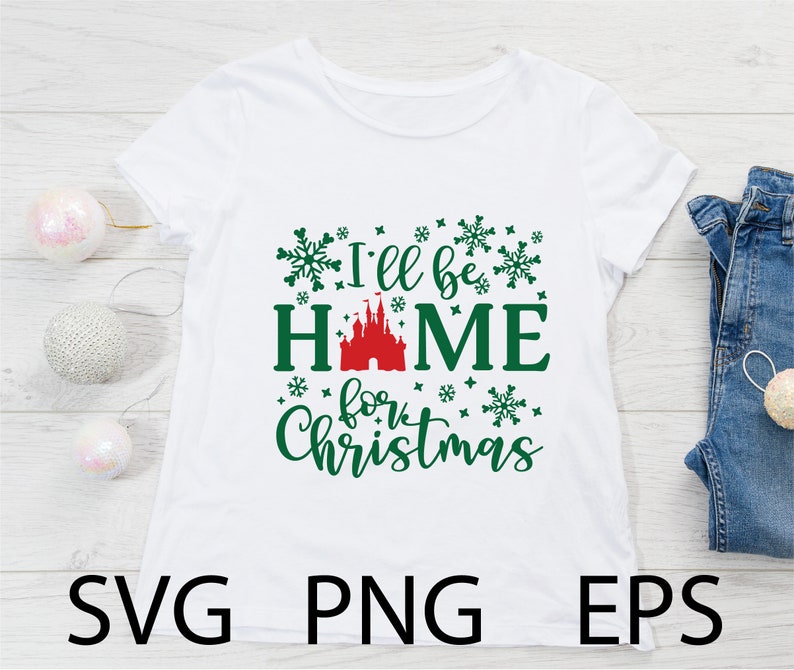 May include: White t-shirt with green text that reads "I'll be home for Christmas". The text is surrounded by green snowflakes. A red castle is in the middle of the word "home".