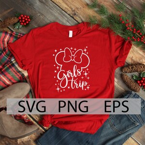 May include: Red t-shirt with a white design of a Mickey Mouse head with a bow and the text "Girls Trip" with white glitter stars.