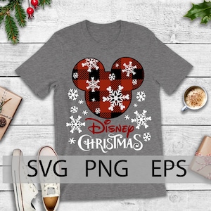 May include: A gray t-shirt with a red and black plaid Mickey Mouse head design and the text "Disney Christmas" in white. The Mickey Mouse head is surrounded by white snowflakes.