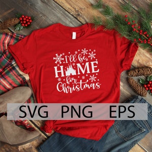 May include: Red t-shirt with white text that reads "I'll be home for Christmas" with a white silhouette of a castle in the middle of the word "home". The shirt is surrounded by snowflakes.