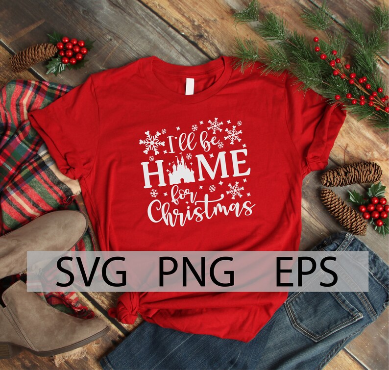 May include: Red t-shirt with white text that reads "I'll be home for Christmas" with a white silhouette of a castle in the middle of the word "home". The shirt is surrounded by snowflakes.