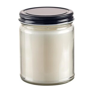 May include: A clear glass jar candle with a black lid. The candle inside is a creamy white color. The jar is cylindrical and has a simple, clean design, suitable for home decor.