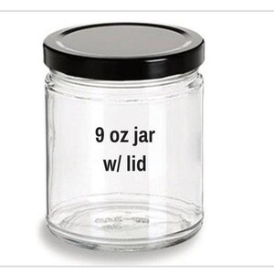 May include: A clear glass jar with a black lid. The jar is labeled "9 oz jar w/ lid". The jar is cylindrical and appears to be empty. The lid is a solid black color.