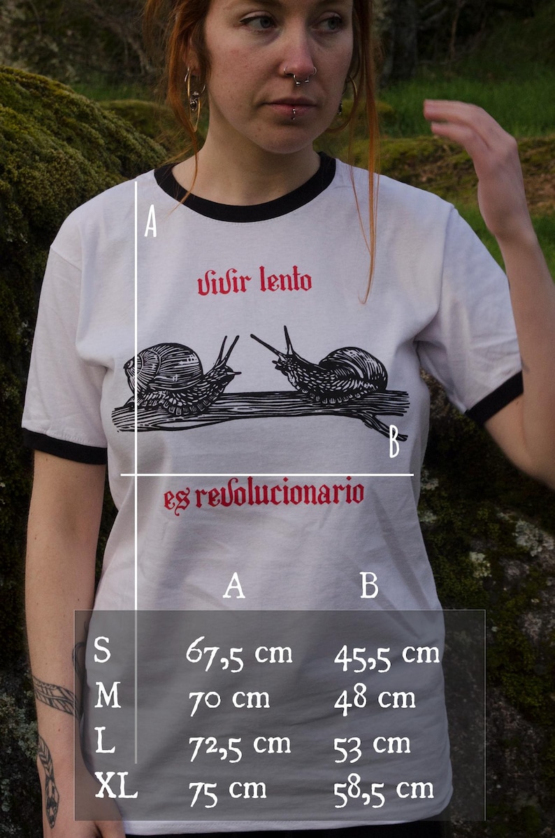 May include: White t-shirt with black trim featuring the Spanish text "Vivir lento es revolucionario" and a graphic of two snails. The shirt's measurements are: S - 67.5 cm x 45.5 cm, M - 70 cm x 48 cm, L - 72.5 cm x 53 cm, XL - 75 cm x 58.5 cm.