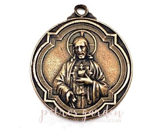 Peut inclure: Pendentif de couleur bronze représentant en relief une figure religieuse avec une auréole, tenant un cœur. Le pendentif a une bordure décorative et une boucle pour l'accrocher. Le texte "petros garden" et "heirloom rosary design" est visible.