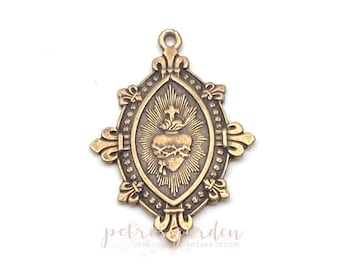 Peut inclure: Un pendentif en métal doré représentant une image détaillée d'un cœur avec des épines et une couronne d'épines. Le cœur est entouré d'un motif de soleil et d'une bordure décorative. Le pendentif est de forme ovale avec un sommet et un bas pointus.