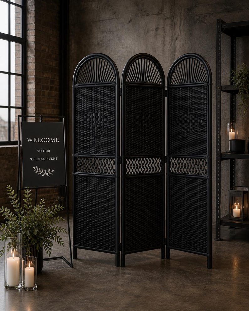 Puede incluir: Un biombo negro tejido con tres paneles, con la parte superior arqueada y un dise&ntilde;o de celos&iacute;a decorativa. Un letrero de bienvenida con el texto "WELCOME TO OUR SPECIAL EVENT" es visible. La escena incluye velas y vegetaci&oacute;n.