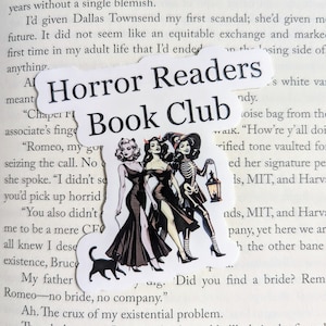 May include: A book club bookmark featuring a black and white illustration of three women in black dresses and a skeleton holding a lantern. The bookmark is titled "Horror Readers Book Club".