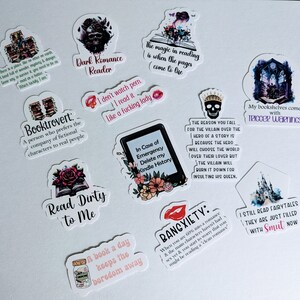 May include: A collection of ten colorful stickers with various book-themed quotes and illustrations. The stickers feature a dark romance reader, a booktrovert, a book a day keeps the boredom away, read dirty to me, in case of emergency delete my kindle history, the reason you fall for the villain over the hero of a story is because the hero will choose the world over their lover but the villain will burn it down for insulting his queen, bangxiety, my bookshelves come with trigger warnings, I still read fairytales they are just filled with smut now, and the magic in reading is when the pages come to life.