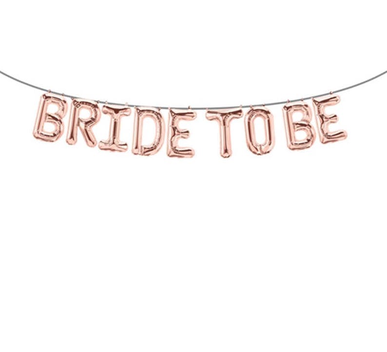 May include: Rose gold foil balloon banner that reads "Bride to Be".