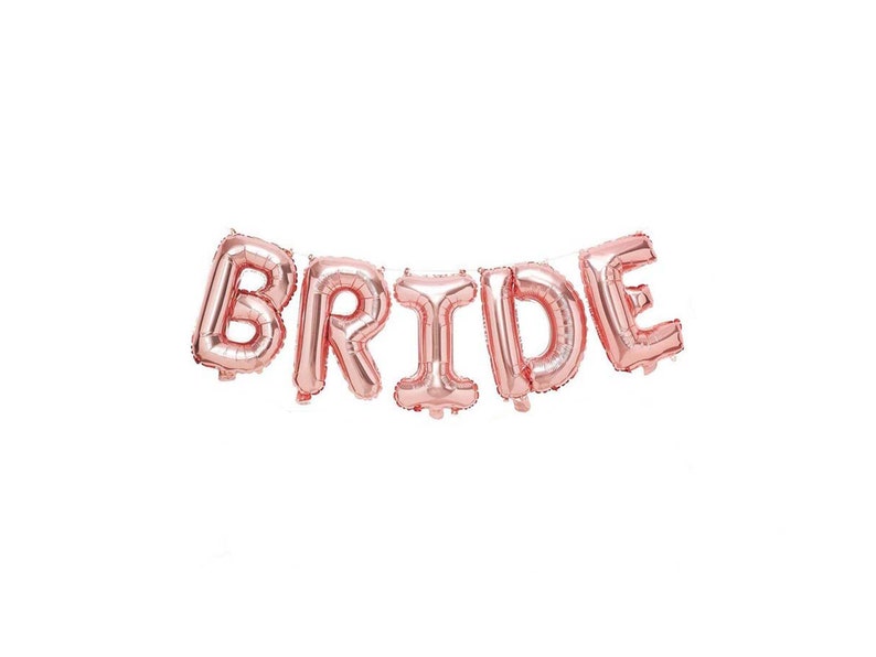 May include: Rose gold foil balloon letters spelling out the word "BRIDE".