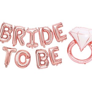May include: Rose gold foil balloons spelling "Bride to Be" with a diamond ring balloon.