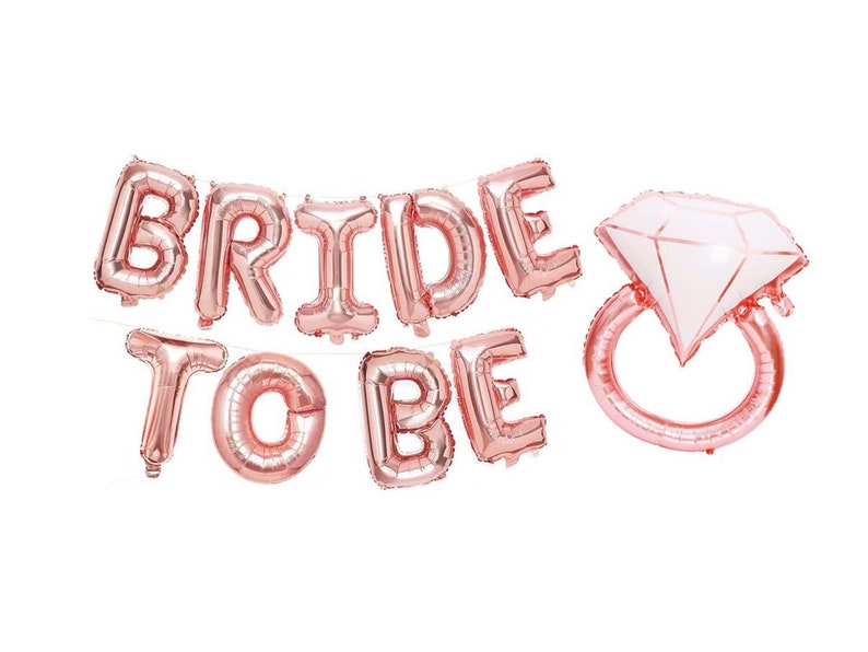 May include: Rose gold foil balloons spelling "Bride to Be" with a diamond ring balloon.