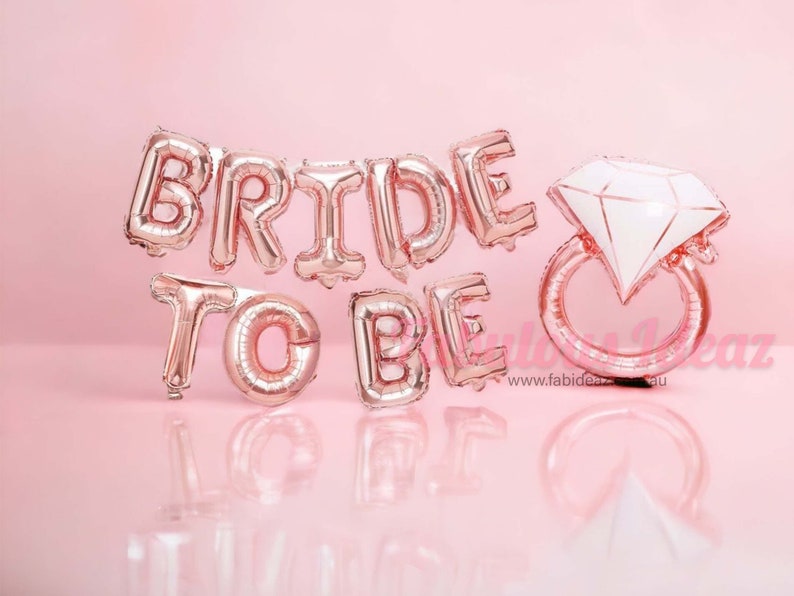 May include: Rose gold foil balloons spelling "Bride to Be" with a large rose gold ring balloon with a white diamond.