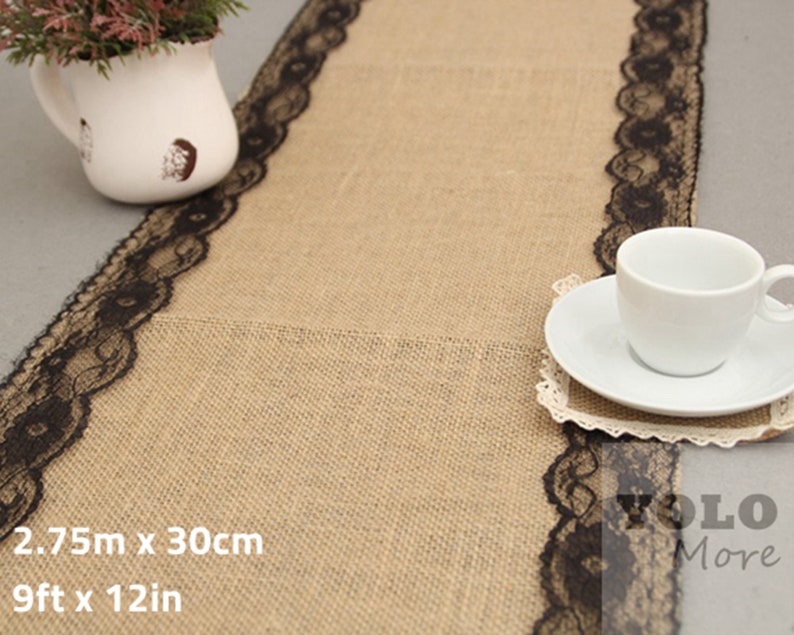 May include: A burlap table runner with black lace trim. The runner is 9 feet long and 12 inches wide. 2.75m x 30cm.