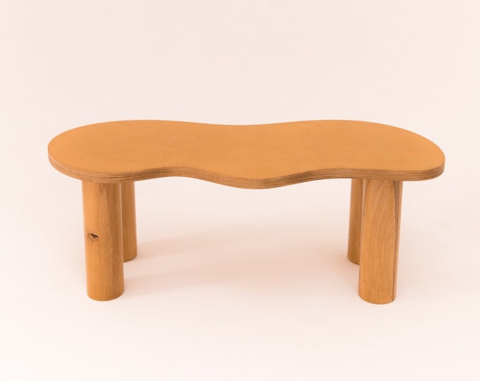 Wooden coffee table with organic shape and pretty curves, honey-tinted oil finish